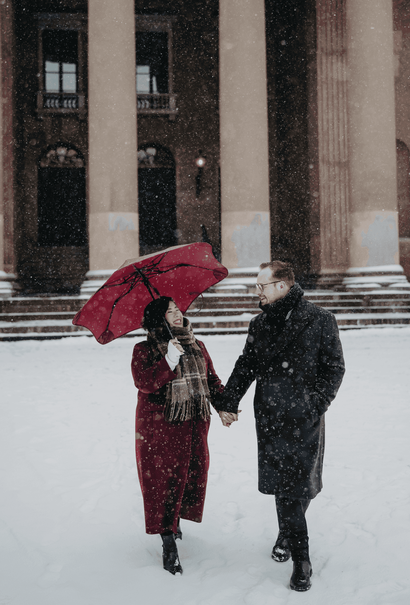 Sarah and Mark walking hand in hand in the snow